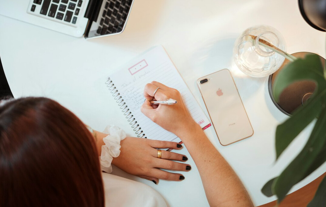 woman writing goals in notebook